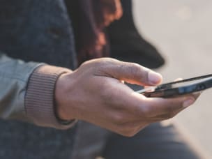 Handy in der Hand in einer Großstadt