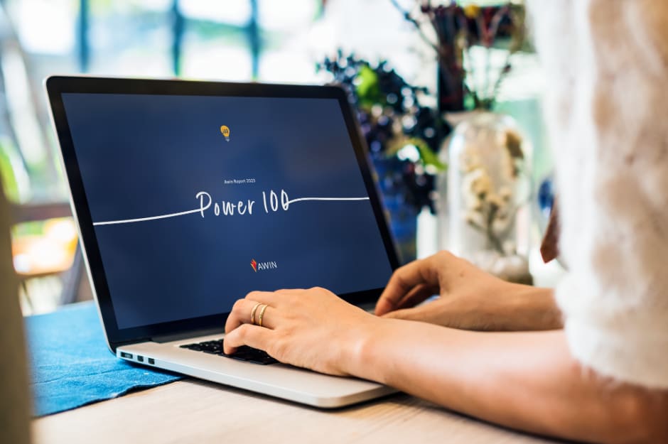 Person typing on laptop, looking at "Power 100" a year after its launch