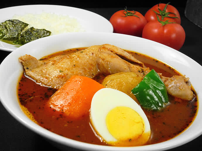 The specialty, “soup curry with chicken on the bone” is served with a large chicken leg.