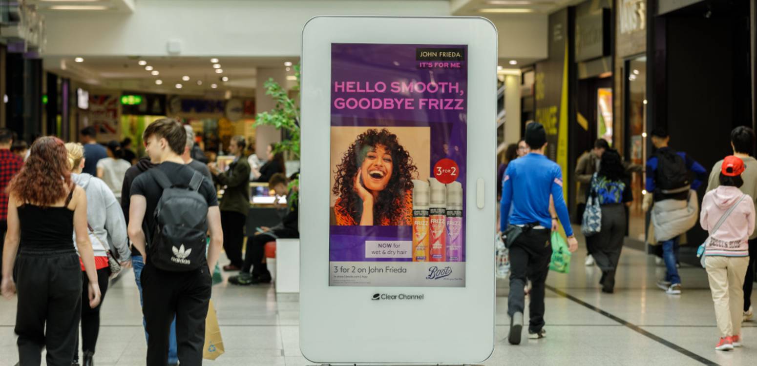 Variety of shopping audience walking past Malls digital screens