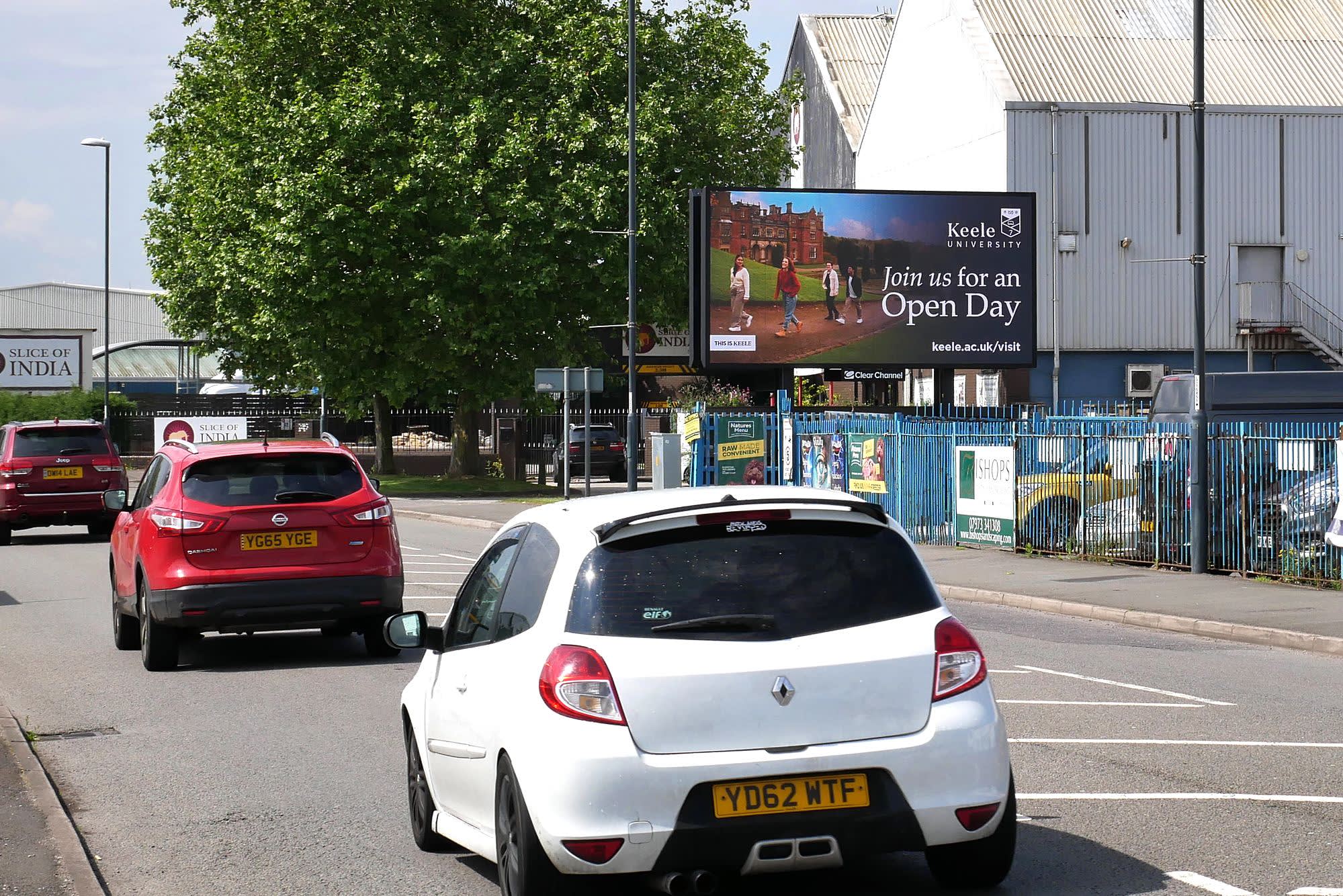 Keele University displaying on a Billboard Live screen next to busy traffic